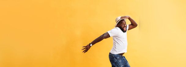 Yakışıklı genç siyah adam karşı sarı arka plan atlama tam uzunlukta - Fotoğraf, Görsel