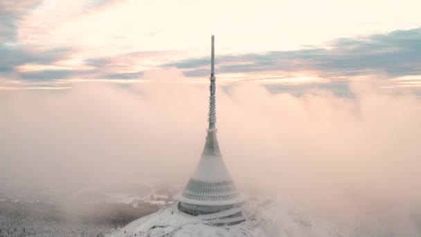 Futurista torre Jested construida en la cima de la montaña forestal cerca de Liberec. Niebla densa rodea la construcción moderna con aguja en vista aérea de invierno - Metraje, vídeo