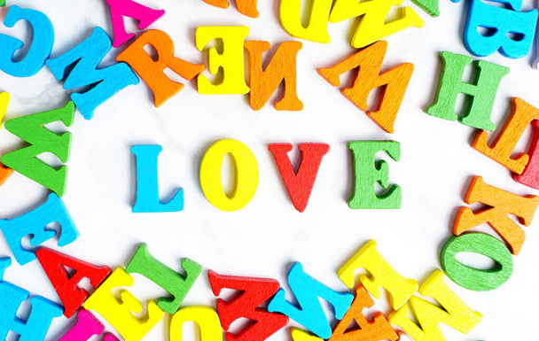Word LOVE made from multicolored wooden letters. Vivid romantic concept. - Fotó, kép