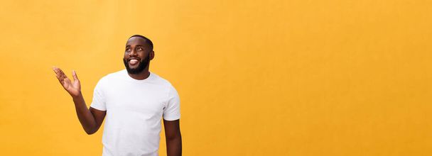 Africano americano homem com barba mostrando mão afastado lado isolado sobre fundo amarelo
. - Foto, Imagem