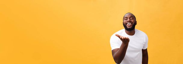 Verbaasd jonge African American hipster dragen witte t-shirt bedrijf handen in verrast gebaar, houden van mond wijd open, op zoek geschokt. - Foto, afbeelding