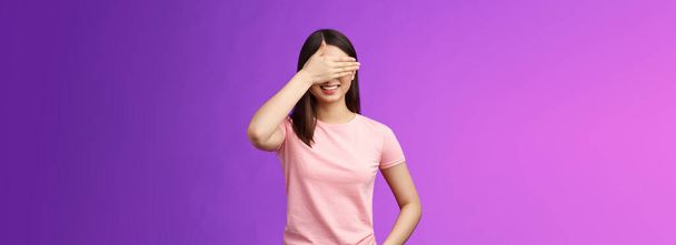 Cute tender stylish asian woman brunette smiling joyfully, anticipating gift, close eyes, cover face palm, awaiting present, cannot wait see what boyfriend prepared, stand purple background. - Photo, Image