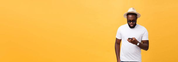 Χαρούμενα αφρικανική αμερικανική άνθρωπος σε άσπρο πουκάμισο χρησιμοποιώντας την κινητή τηλεφωνική εφαρμογή. ευτυχισμένος σκούρο δέρμα hipster τύπος Διαβάστε ειδήσεις από κοινωνικό δίκτυο στο κινητό τηλέφωνο - Φωτογραφία, εικόνα