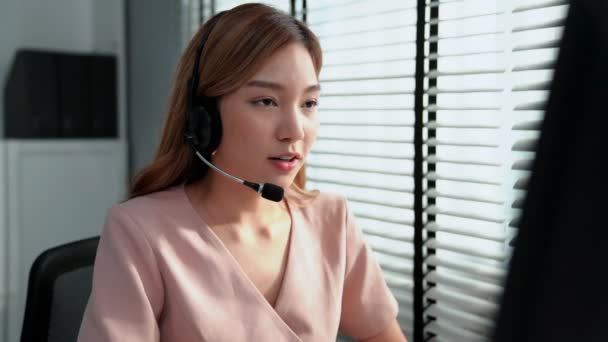 Competent female operator working on computer and while talking with clients. Concept relevant to both call centers and customer service offices. - Materiaali, video