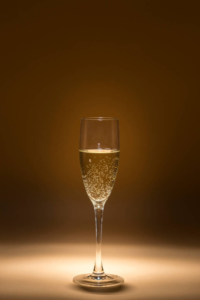 view of a glass of cava in the foreground lit up around it twilight - Fotó, kép