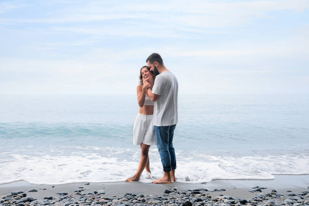 Happy young couple on beach near sea - Zdjęcie, obraz