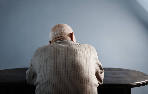 Вид сзади на пожилого человека, сидящего за столом - Фото, изображение