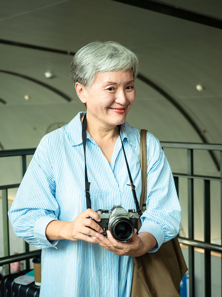 Portrait de heureuse femme âgée âgée asiatique des années 60 prenant des photos avec appareil photo pour le concept de voyage. - Photo, image