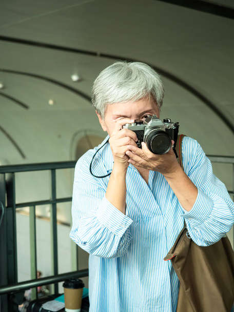 Muotokuva onnellinen vanhempi aikuinen vanhukset Aasia nainen 60s ottaa kuvia valokuva kamera matkustaa käsite. - Valokuva, kuva