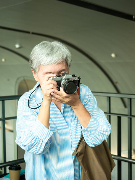 Portrait de heureuse femme âgée âgée asiatique des années 60 prenant des photos avec appareil photo pour le concept de voyage. - Photo, image