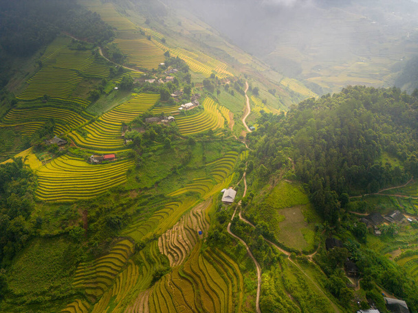 Aerial view of golden rice terraces at Mu cang chai town near Sapa city, north of Vietnam. Beautiful terraced rice field in harvest season in Yen Bai, Vietnam. Travel and landscape concept. Selective focus - Foto, Bild