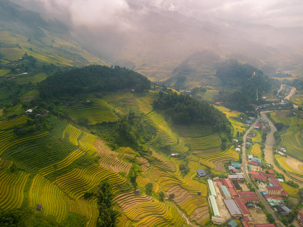 Aerial view of golden rice terraces at Mu cang chai town near Sapa city, north of Vietnam. Beautiful terraced rice field in harvest season in Yen Bai, Vietnam. Travel and landscape concept. Selective focus - Zdjęcie, obraz