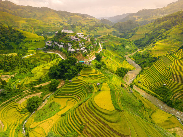 Aerial view of golden rice terraces at Mu cang chai town near Sapa city, north of Vietnam. Beautiful terraced rice field in harvest season in Yen Bai, Vietnam. Travel and landscape concept. Selective focus - Zdjęcie, obraz