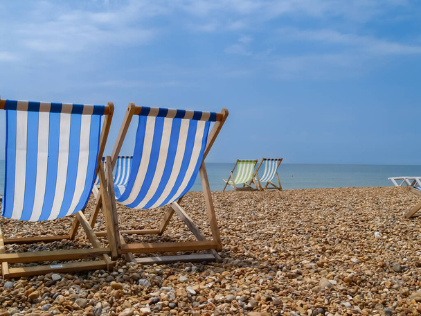 Brighton Beach und charakteristische gestreifte Strandkörbe in blau oder rot und weiß. - Foto, Bild
