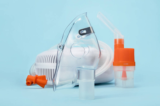 Zavřít dýchací masku pro nebulizátor kompresoru na modrém pozadí. Zdravotnické vybavení pro inhalační léčbu astmatu a respiračních onemocnění. - Fotografie, Obrázek