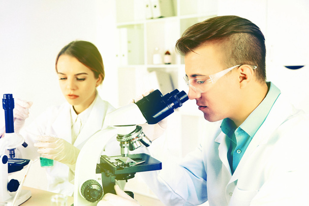 Young male researcher carrying out scientific research in lab - Fotoğraf, Görsel
