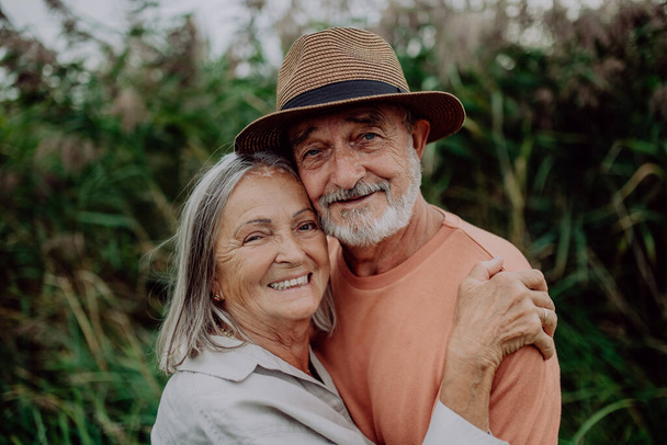 Portrait of senior couple in love, standing outdoor in the nature. - Photo, image