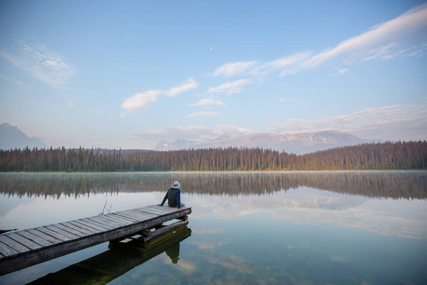 Ein Mann ruht sich am ruhigen See aus. Erholungsurlaub - Foto, Bild