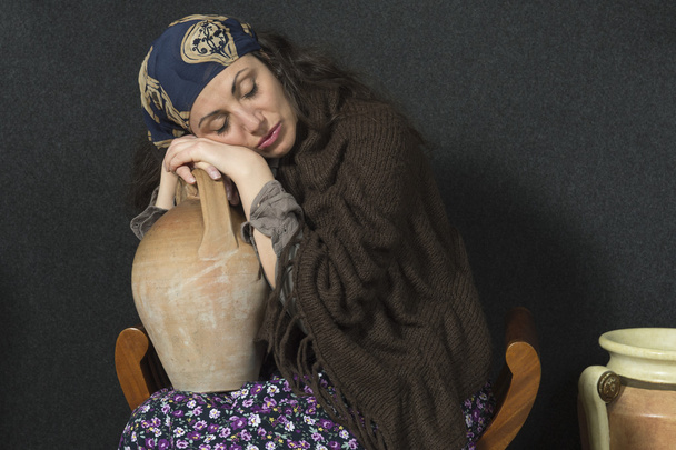 Vrouw met haar hoofd rustend op zijn handen ter ondersteuning van een ' Amfora - Foto, afbeelding