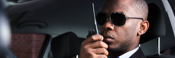 Private Detective Or Investigator. African Security Using Walkie Talkie - Foto, afbeelding