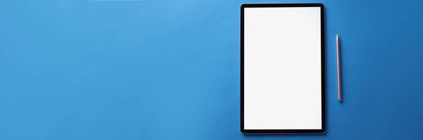Top view of set of black screen modern tablet device with reflection and silver pen on blue surface, turnoff gadget. Technology, mockup concept. Copy space - Фото, изображение
