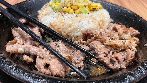 selective focus grilled beef steak with korean sauce bulgogi on top of rice with slice of pepper and sweet corn - korean and japanese food style in a restaurant - Photo, Image