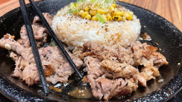 Kore soslu ızgara biftek ve yanında pirinç, biber ve mısır dilimleri. Kore usulü ve Japon usulü bir restoranda. - Fotoğraf, Görsel