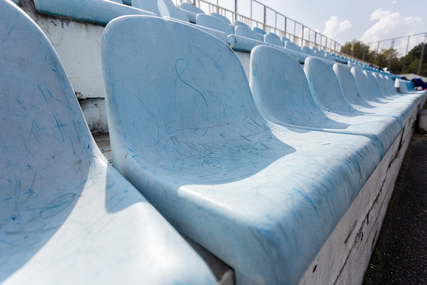 Reihen alter Plastiksitze auf leerem Stadion  - Foto, Bild