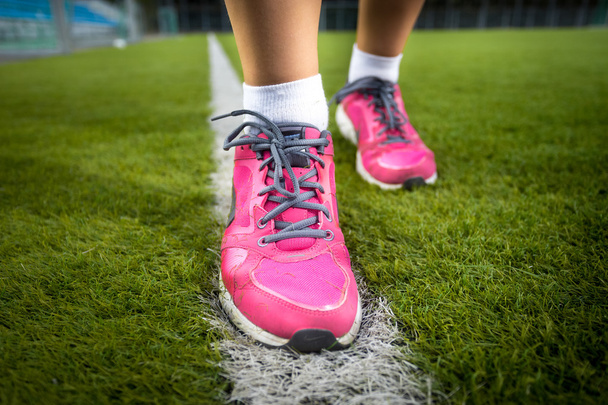Mujer en zapatillas de deporte de color rosa corriendo sobre hierba fresca
 - Foto, imagen