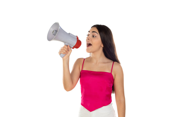 Giovane donna bruna urla con un megafono su uno sfondo bianco  - Foto, immagini