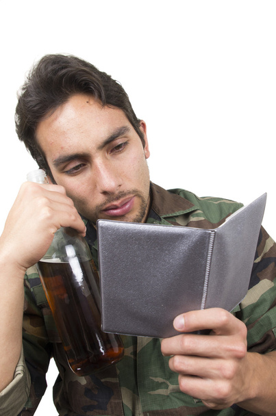distraught military soldier veteran holding a bottle and looking at photos ptsd - Foto, imagen