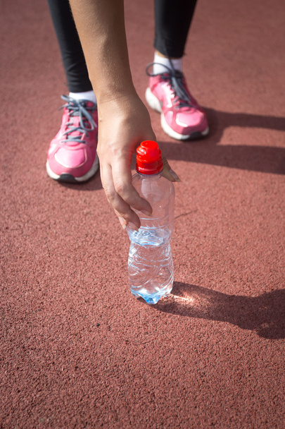 donna sportiva che prende una bottiglia d'acqua dalla pista di corsa
 - Foto, immagini
