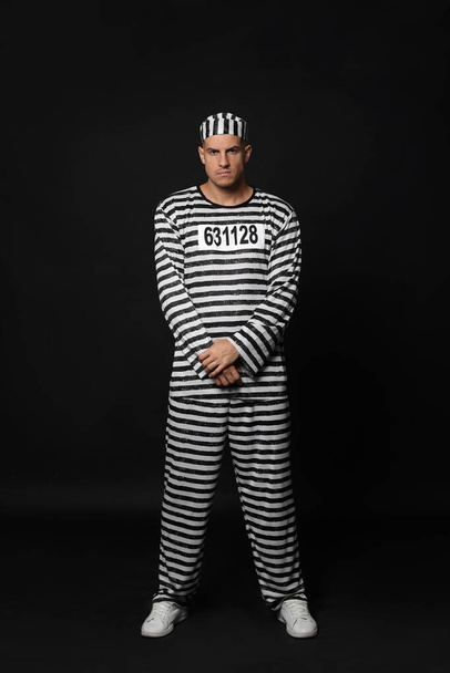 Prisoner in striped uniform on black background - Φωτογραφία, εικόνα