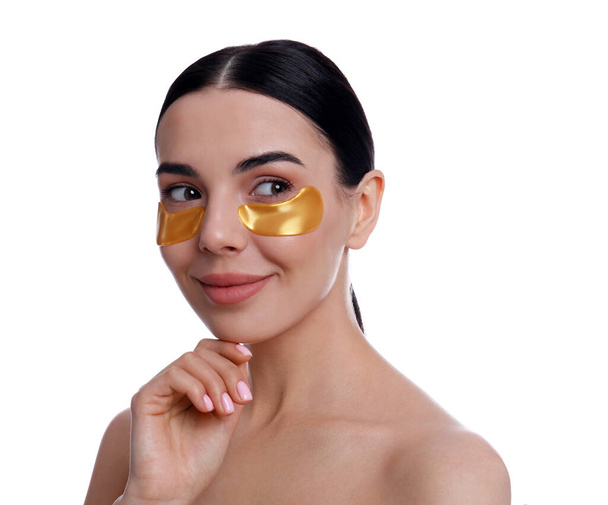 Beautiful young woman with under eye patches on white background - Φωτογραφία, εικόνα