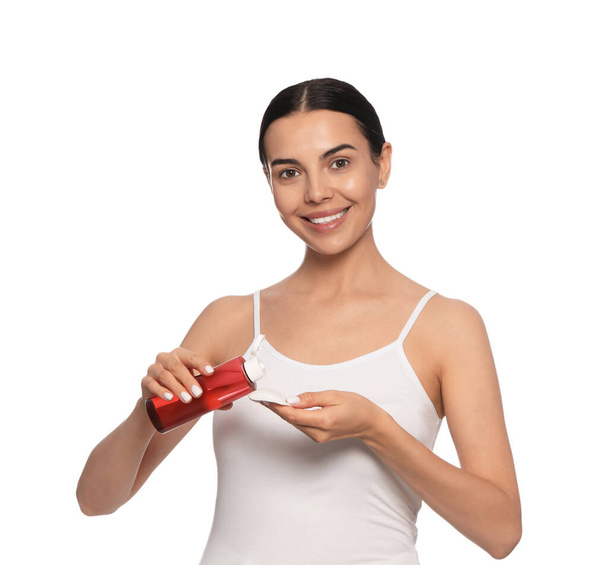 Young woman pouring micellar water onto cotton pad on white background - Φωτογραφία, εικόνα
