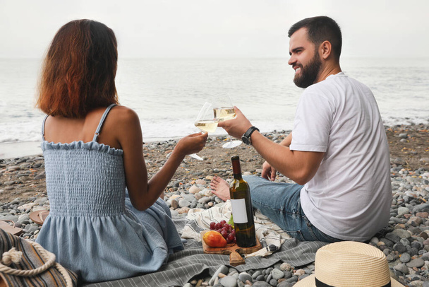 Happy young couple having picnic on beach near sea - Fotó, kép