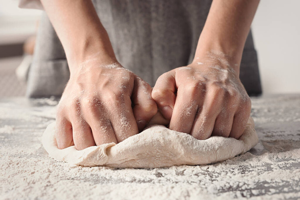 Woman kneading dough at table in kitchen, closeup - Φωτογραφία, εικόνα