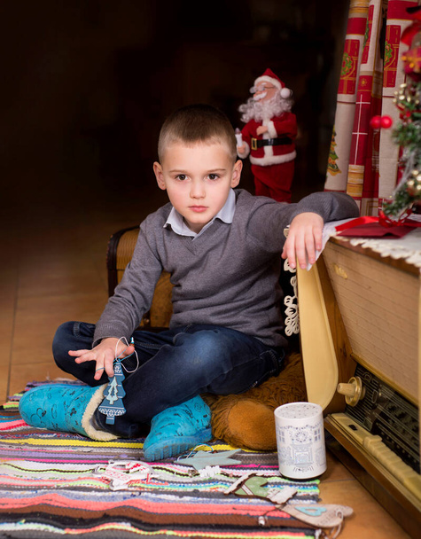 boy in the interior of the house decorated for the new year and christmas - Photo, Image