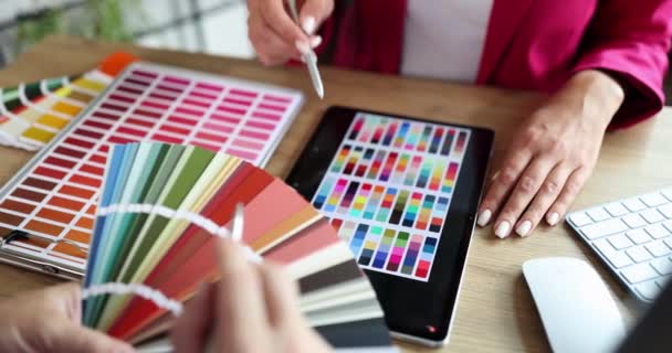 Egy nő az irodában összehasonlítja a színmintákat egy közeli palettáról. Grafikus tervezői munkahely koncepció - Felvétel, videó