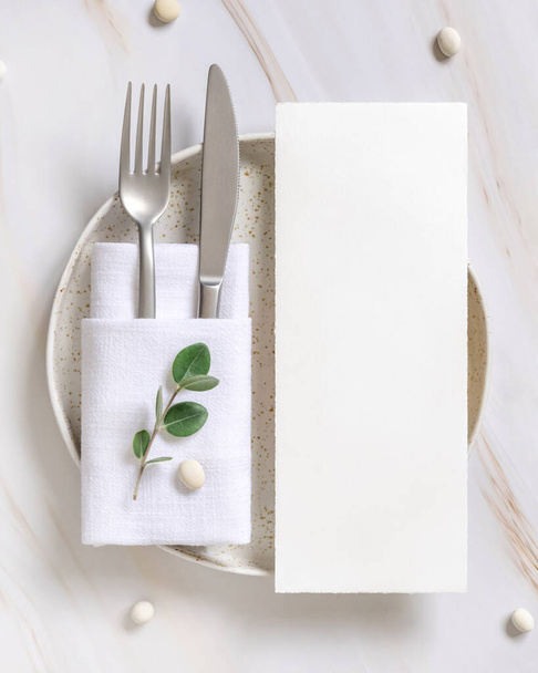 Elegant Table setting with card and envelope decorated with eucalyptus branches  top view, Wedding Mockup. Romantic table with vertical paper card. Close to nature and simplicity concepts - Photo, image