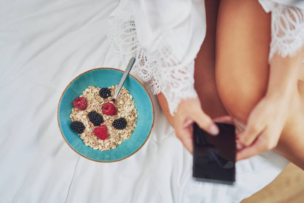 Mooie brunette op bed met ontbijtgranen. Hoge kwaliteit foto - Foto, afbeelding