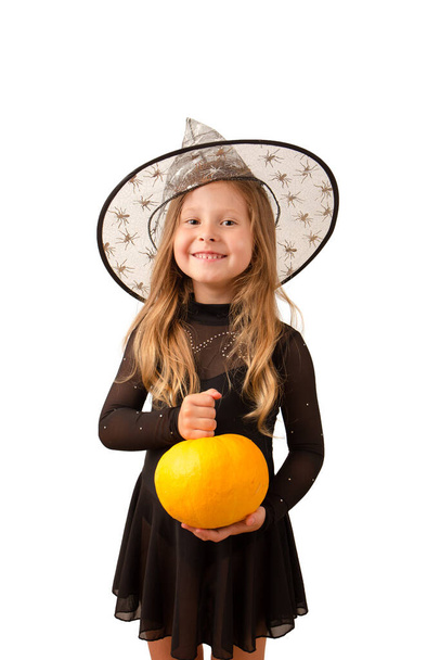 A little witch with a pumpkin isolated on white background. Halloween concept - Fotoğraf, Görsel