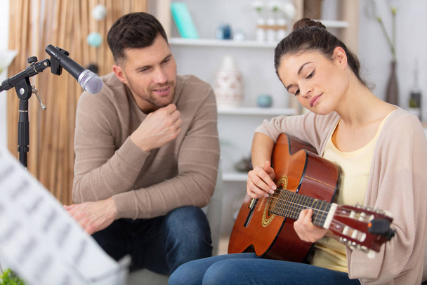 man teaching his girlfriend playing guitar - Foto, afbeelding