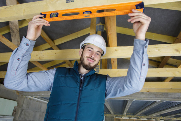 worker checks the level of wooden house structure - Φωτογραφία, εικόνα