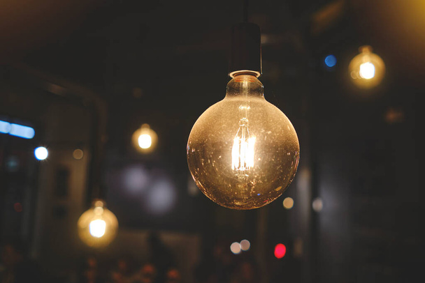 Установка ретро-лампы Эдисон на темном фоне боке, выборочная фокусировка. - Фото, изображение