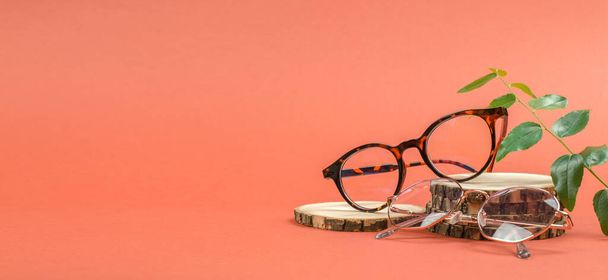 Elegantes gafas redondas en un podio de madera. Banner de venta de gafas - Foto, imagen