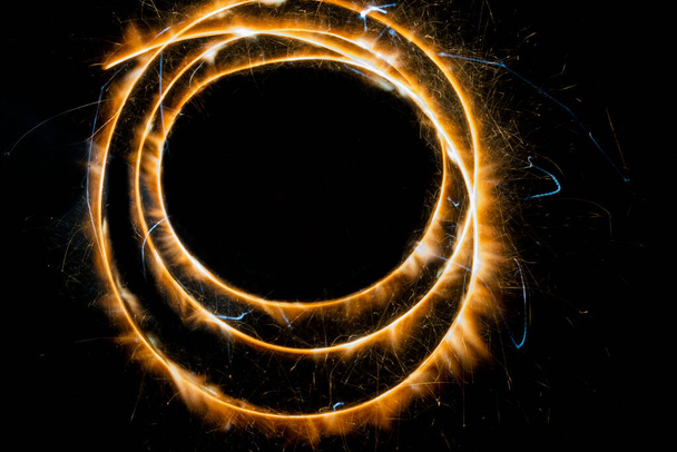 Shinning sparkles making circle of light on black banner. - Photo, image