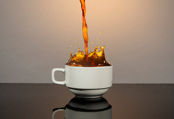 Coffee splash going out of white cup - hot drink concept. - Fotó, kép