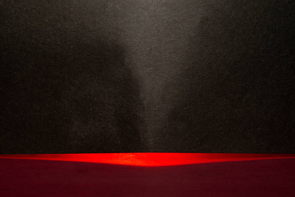 Luz abstracta roja que pasa a través de la tarjeta negra haciendo fondo. - Foto, imagen