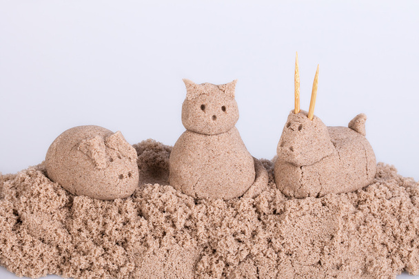 Katzenskulptur aus nassem Sand auf weißem Hintergrund - Foto, Bild